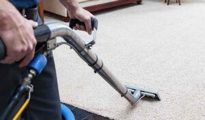 Carpet cleaner removing stains from an Ames apartment living room during a move-out service.