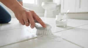 Scrubbing grout lines with a brush and baking soda paste — DIY tile and grout cleaning